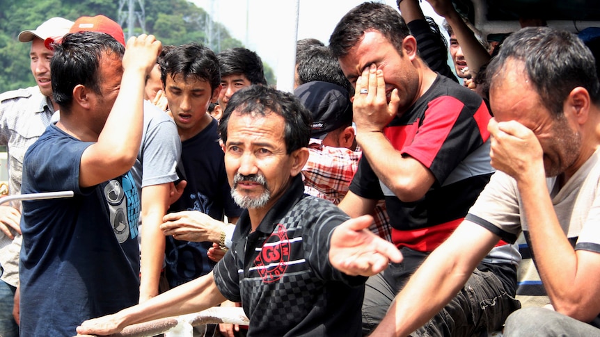 Asylum seekers cry as Indonesian officers force them to leave the Australian vessel Hermia.