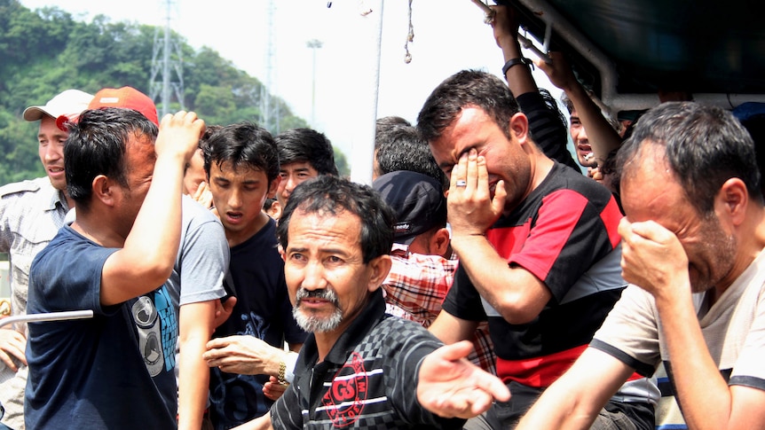 Asylum seekers on boat docked at Merak