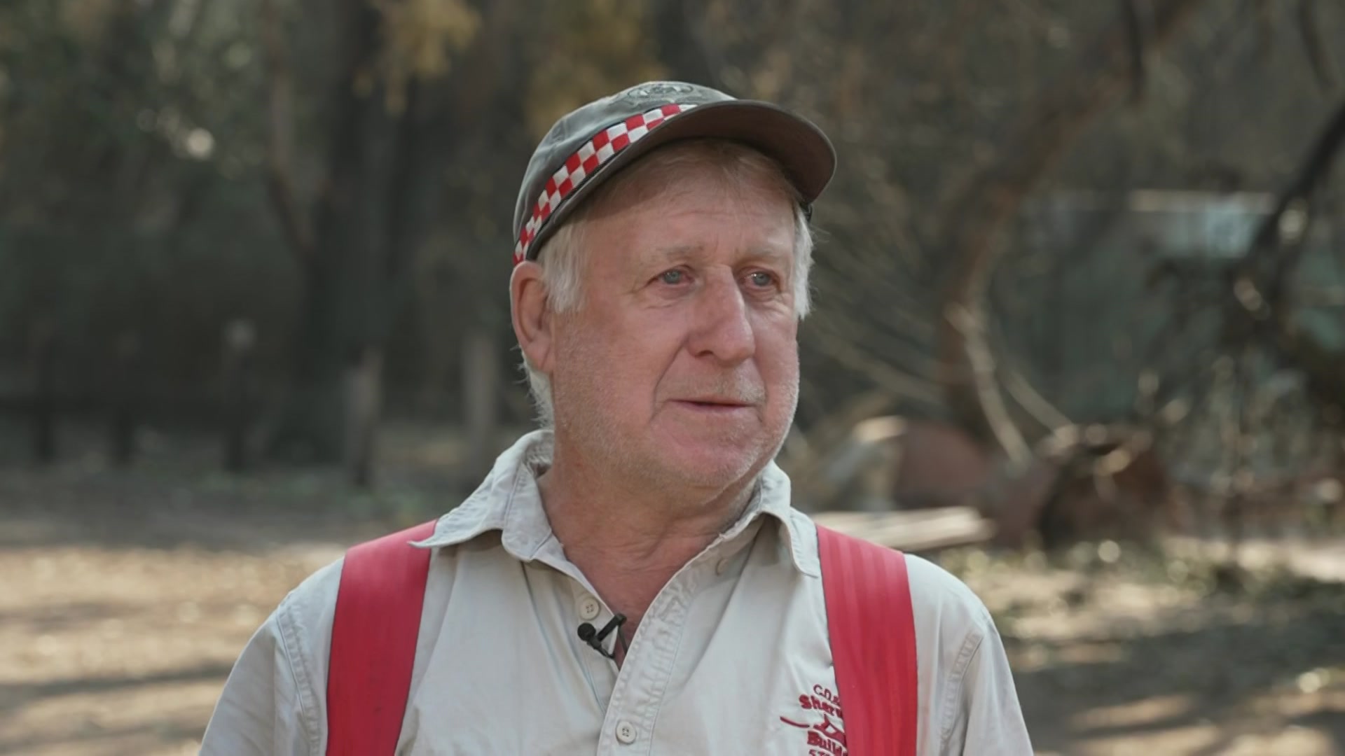 Theo habla serio, lleva sombrero, camisa gris y gorra CFA.