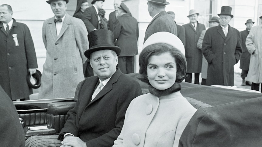 Jackie Kennedy sits alongside JFK in the backseat of a convertible following his inauguration as US president in 1961. 