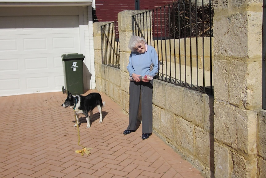 Dawn Baldwin standing in a driveway with a black and white dog.