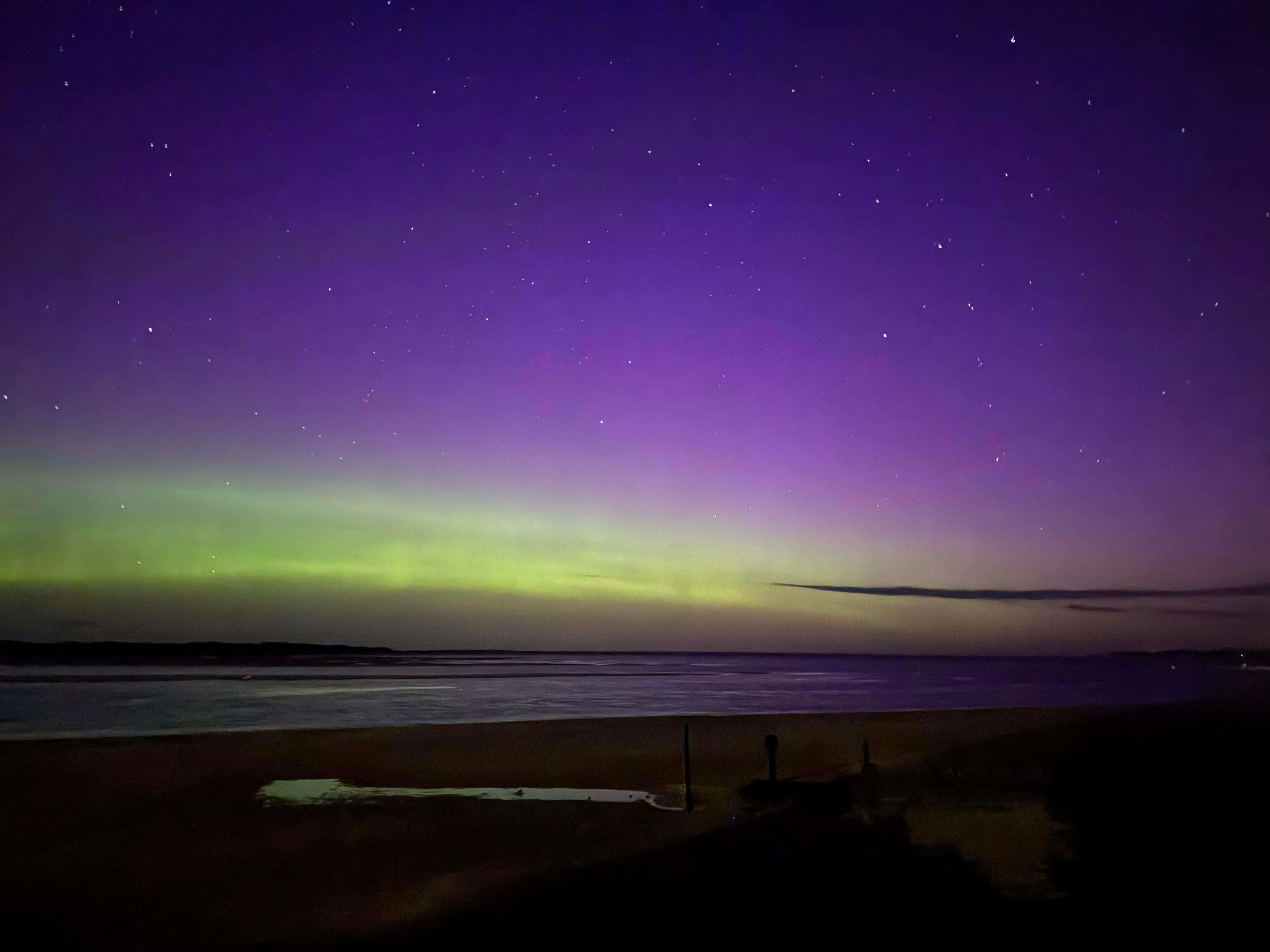 Aurora Australis ilumina la playa por la noche.