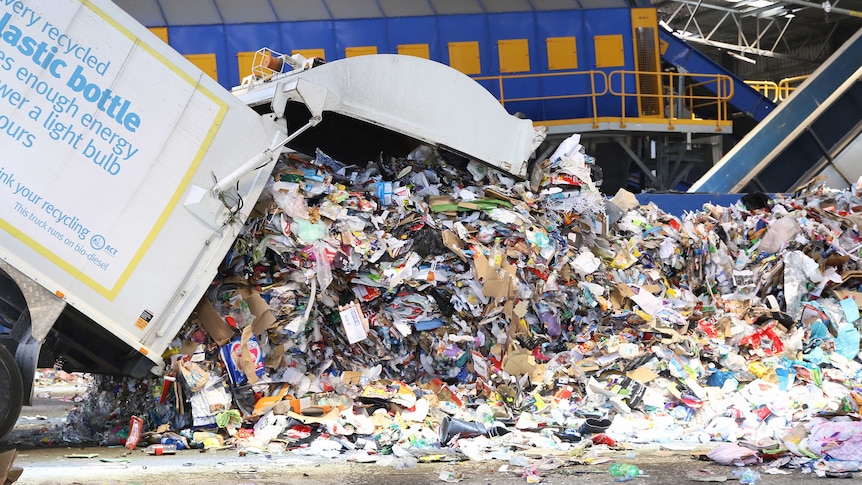 A truck dumps cardboard for recycling at Re Group's Hume facility