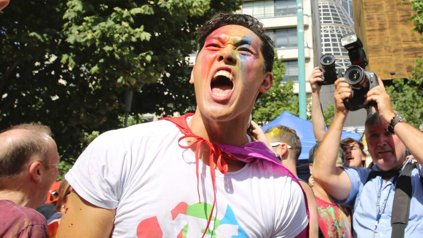 A man with a painted face in Melbourne yells as the official announcement is made.