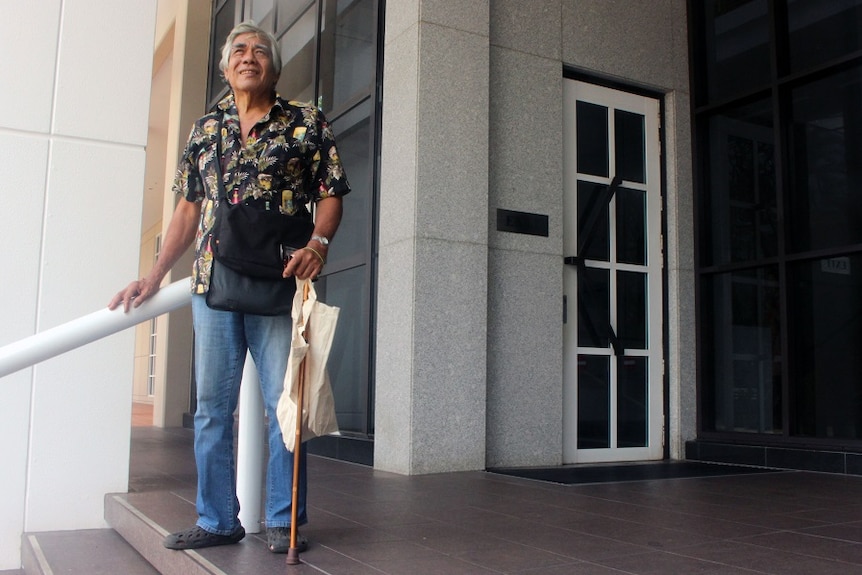 James Nasir stands on some steps and looks at the sky