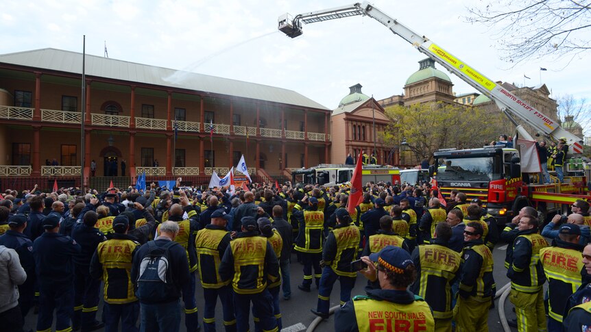 Hundreds of Fire and Rescue NSW trucks and their crews hose down NSW State Parliament during a protest