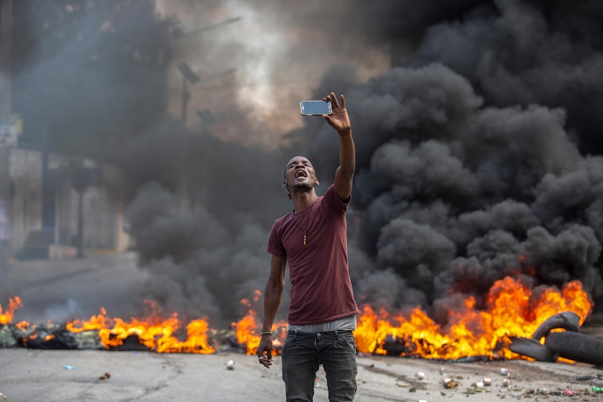 Man takes a selfie in front of fire