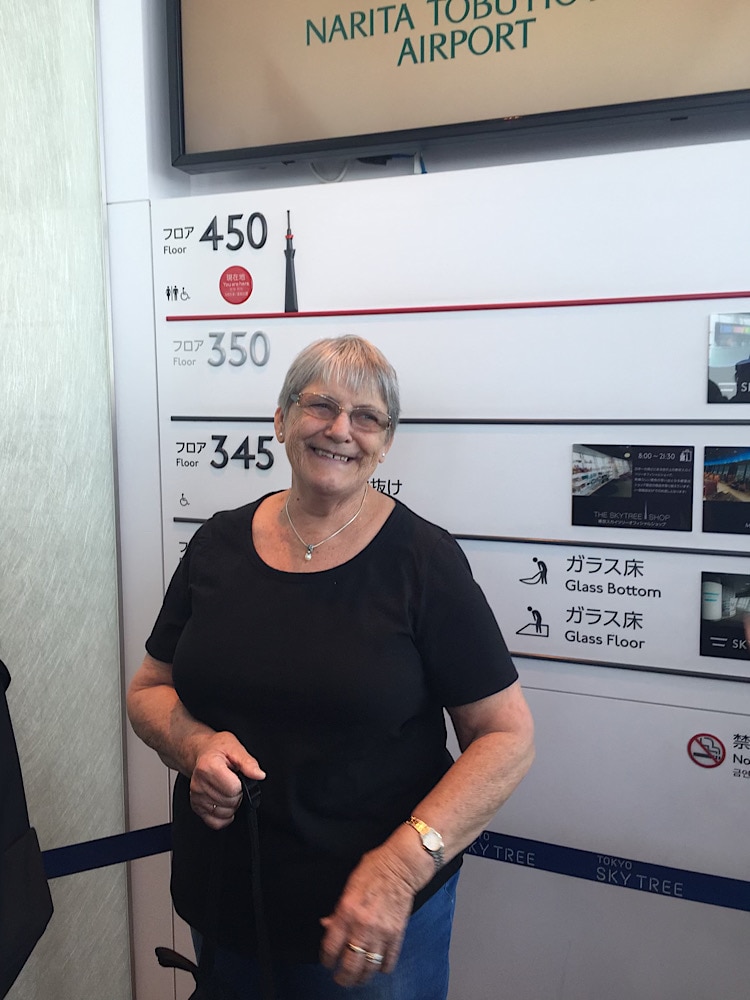 Older woman smiling in front of pictures