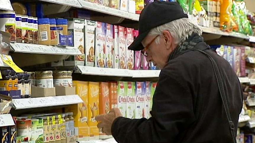 A man looks at items on supermarket shelves.