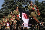 Afghan soldiers lead a procession with a wreaths and a portrait of slain former president Burhanuddin Rabbani
