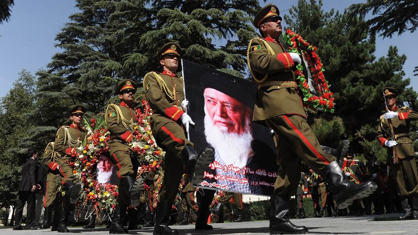 Afghan soldiers lead a procession with a wreaths and a portrait of slain former president Burhanuddin Rabbani