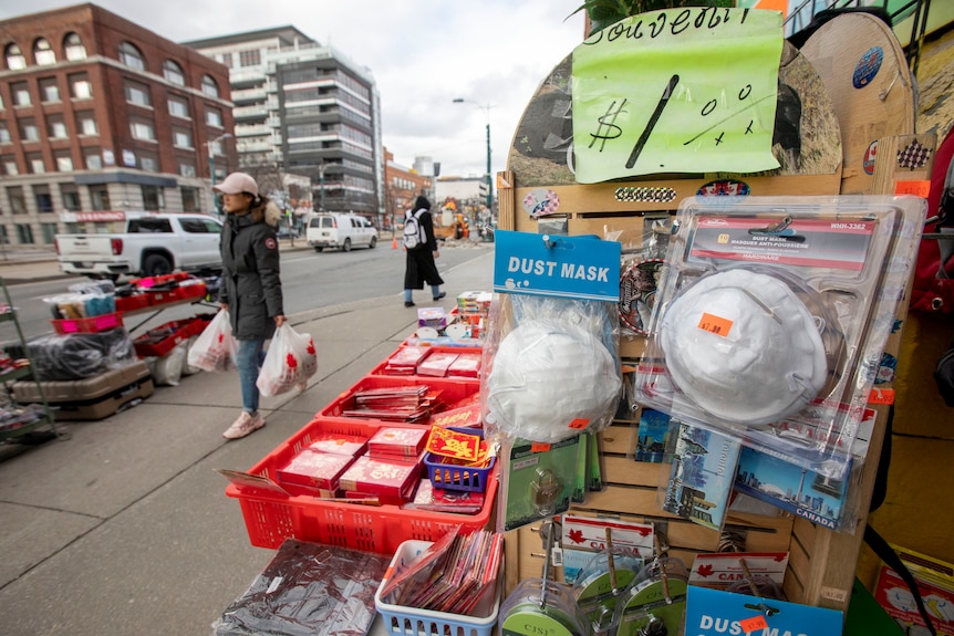 A group of masks hanging on a street stall in Toronto