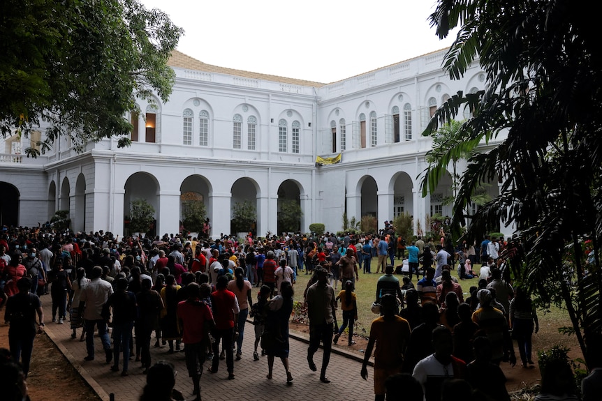 Crowds stand outside the colonial style presidential palace in Colombo.