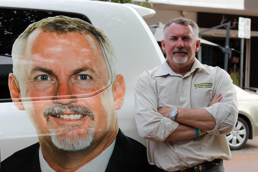 Paul Brown standing next to a car with his image emblazoned on it.