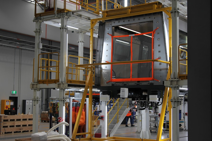 A picture of a partially-built train carriage on a platform where it is being assembled. 