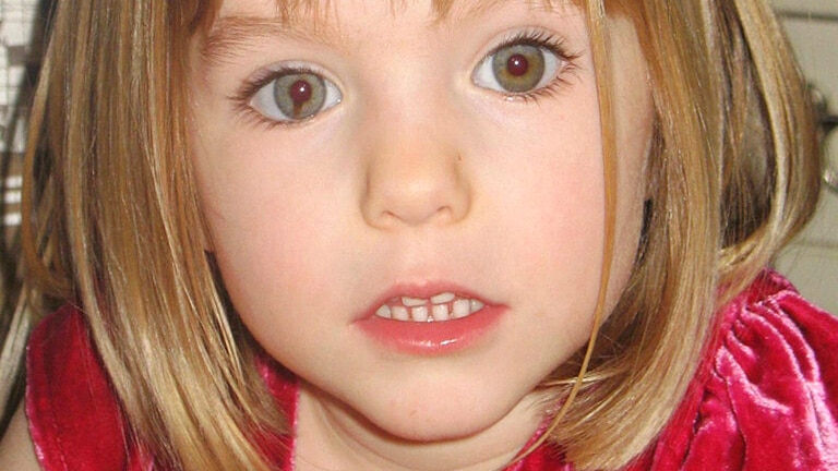 A close up head shot of a young girl with blonde hair and blue eyes.
