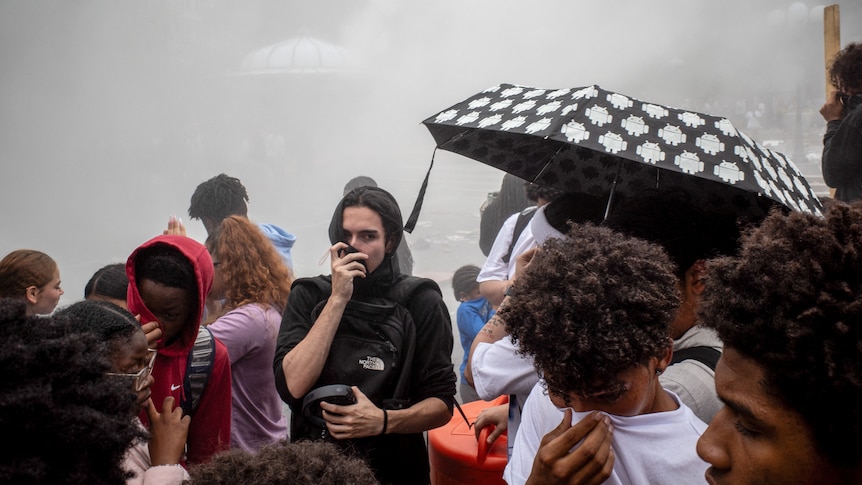 People protecting their faces from smoke.