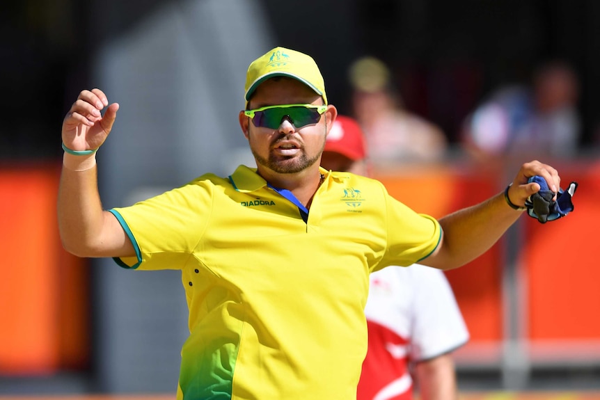 Aaron Wilson of Australia celebrates winning an end in lawn bowls against Robert Paxton of England.