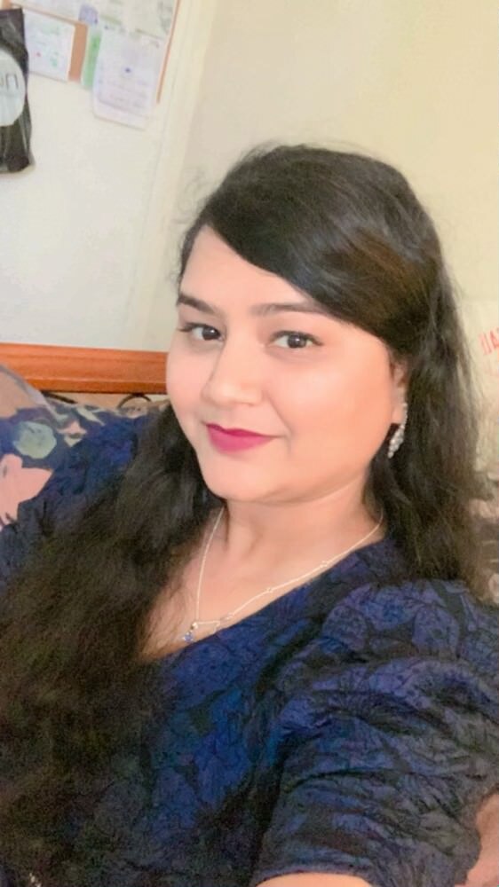 A woman looks at the camera smiling