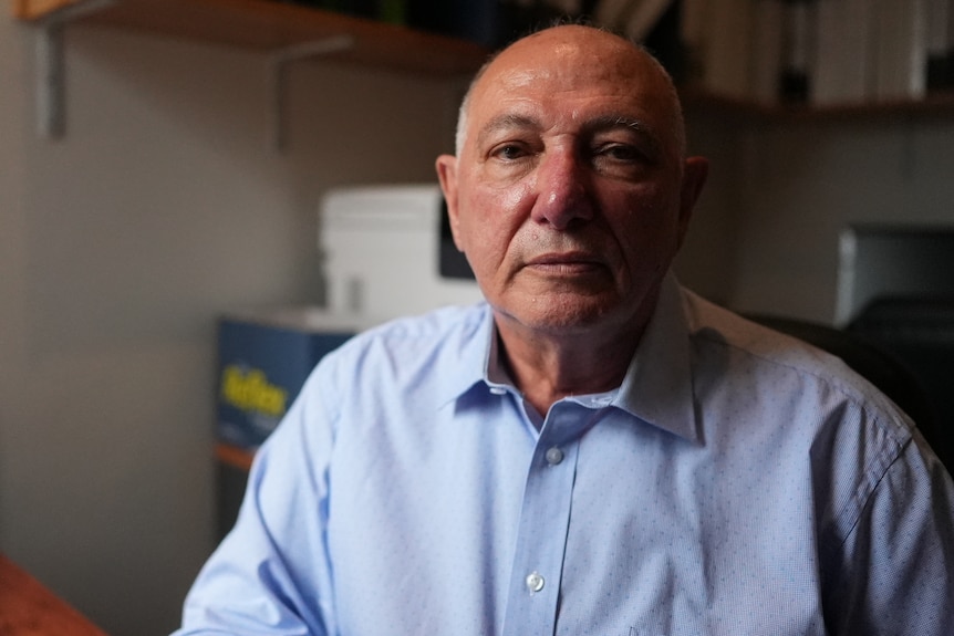 a man sitting in a dark room looking serious