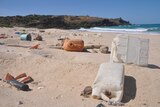 trash lies across a remote beach