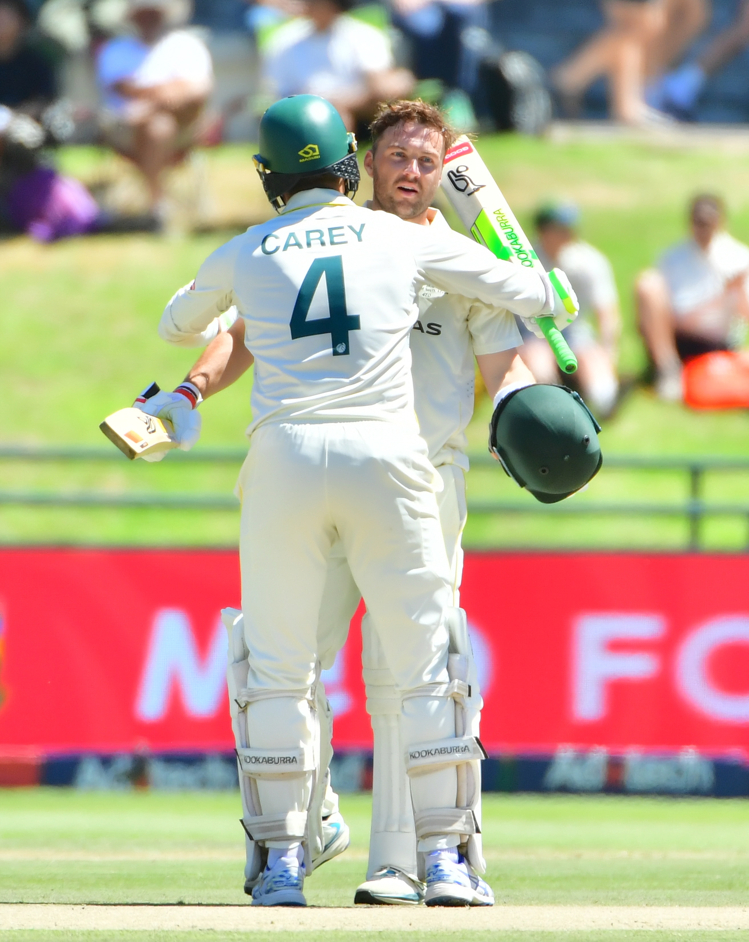 Australia batters Josh Inglis and Alex Carey hug on the pitch during a Test against South Africa.