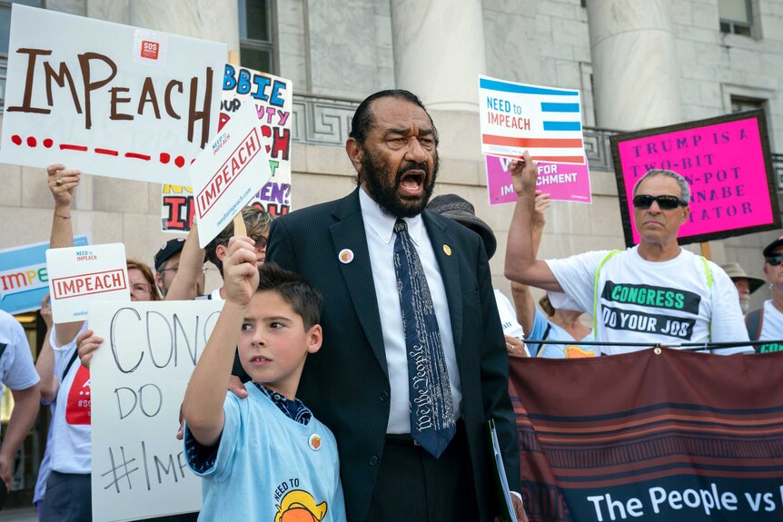 Activists and Al Green hold placards demanding Trump's impeachment, standing on Capitol Hill.