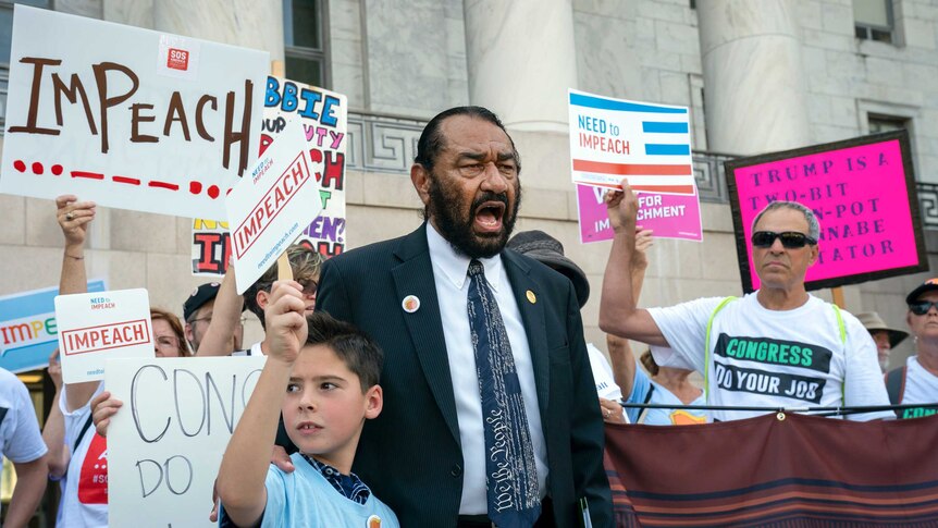 Activists and Al Green hold placards demanding Trump's impeachment, standing on Capitol Hill.
