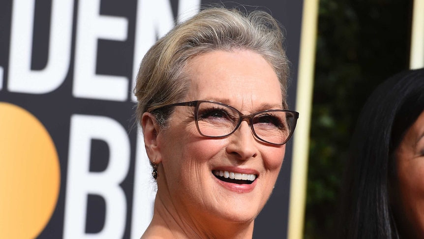Meryl Streep smiling on the red carpet at the Golden Globes.
