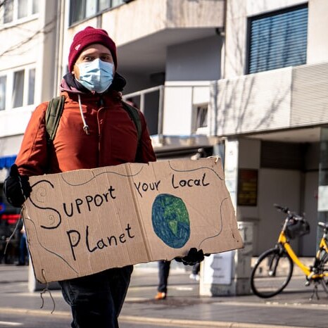 Man walks and holds climate change protest sign