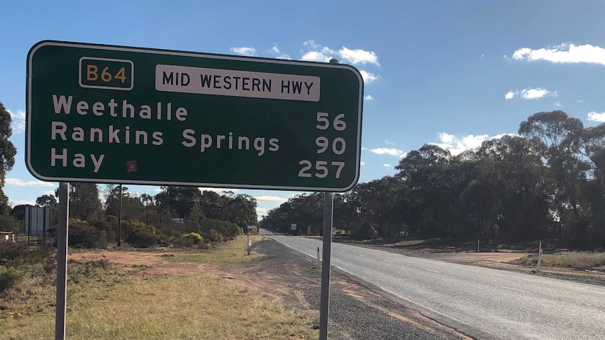 Green road sign next to road