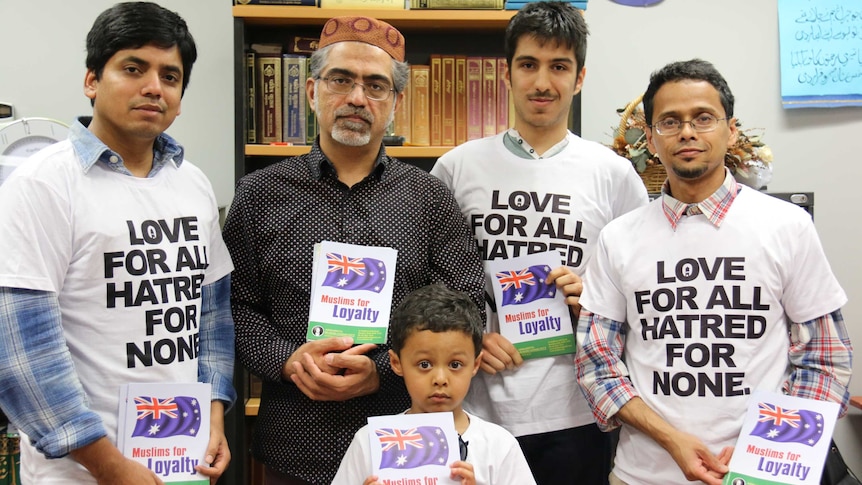 Members of the group pose with the leaflets in an office.