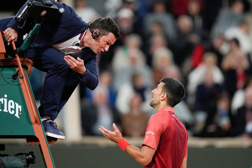 Tennis player Novak Djokovic speaks to chair umpire Nico Helwerth during a match at the French Open.
