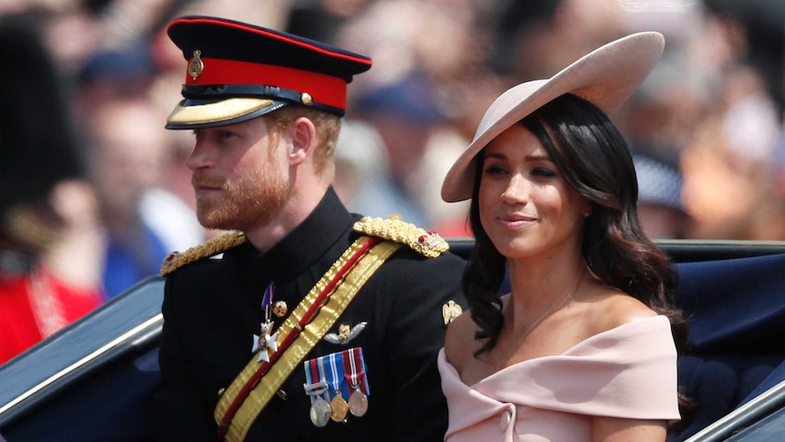 A young couple, dressed formally, sits in an open carriage with a man in similar garb and a very tall hat