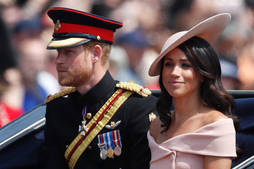 A young couple, dressed formally, sits in an open carriage with a man in similar garb and a very tall hat