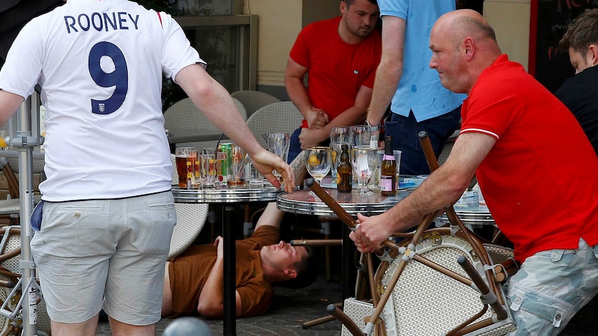 An England fan lies stricken on the ground after clashes with Russian supporters