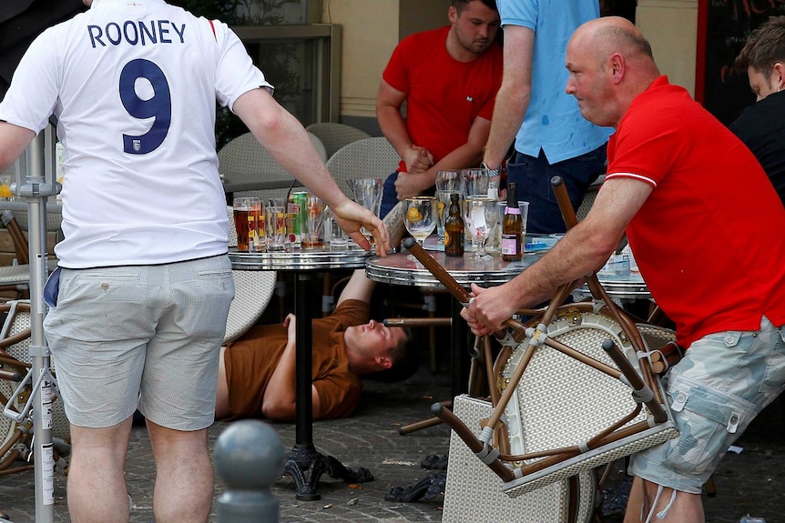 An England fan lies stricken on the ground after clashes with Russian supporters