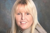 a close up portrait image of Vicki White, with long blonde hair, in uniform