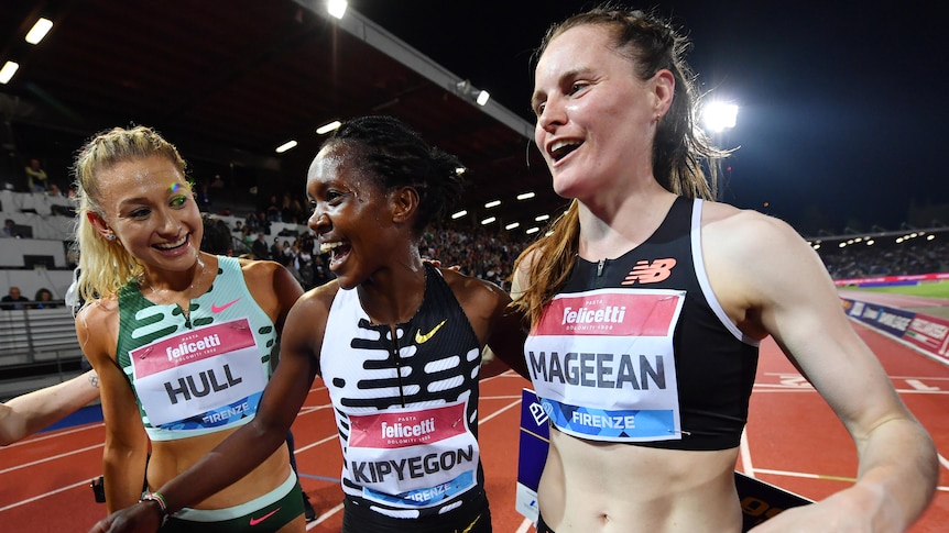 Three female athletes celebrate after a world record was set in Florence.