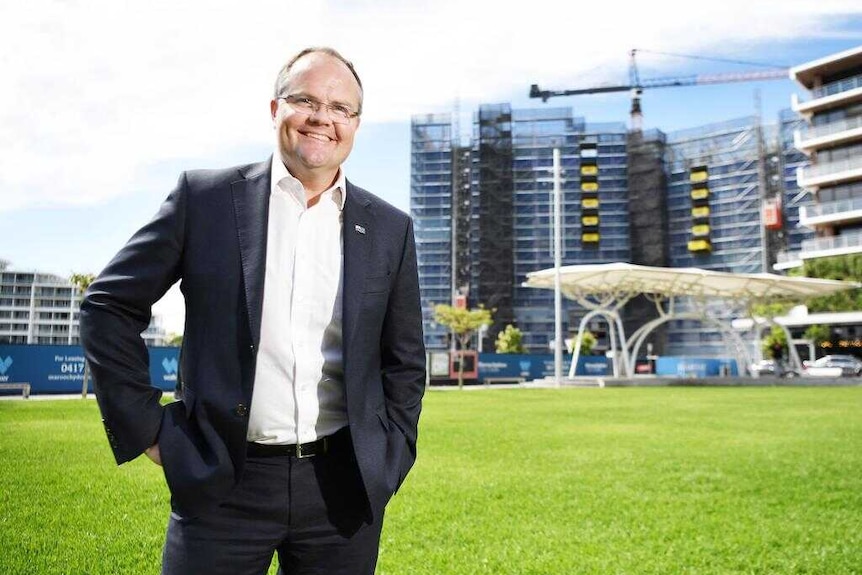 Man standing on grass in front of building site