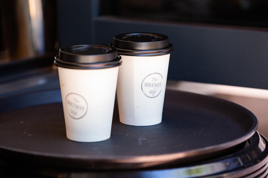 Tasses à café à emporter assis sur un plateau.