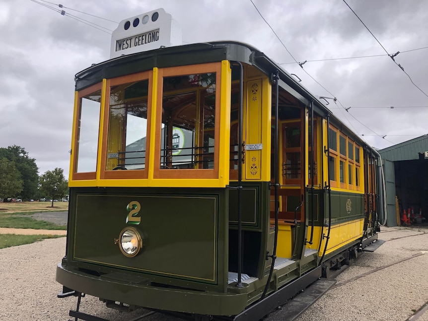 A green and yellow historic tram