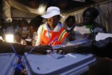 A Zimbabwe election observer checks the seal on ballot boxes at the end of polling in Harare.