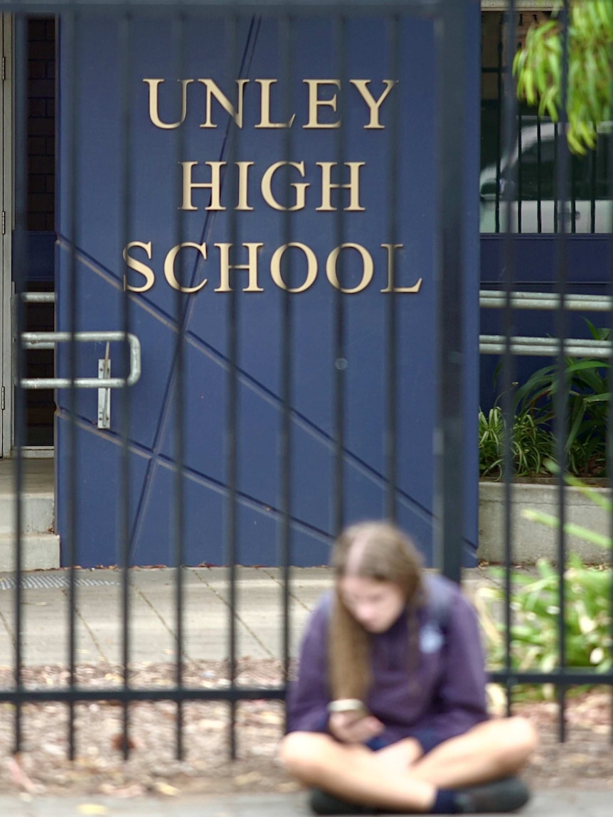A student sits in front of the Unley High School.