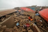 A woman cooks a meal outdoors after her house was damaged by Cyclone Fani.