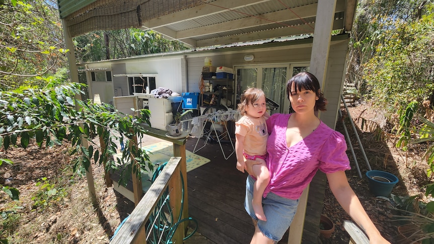 A woman and child outside a house