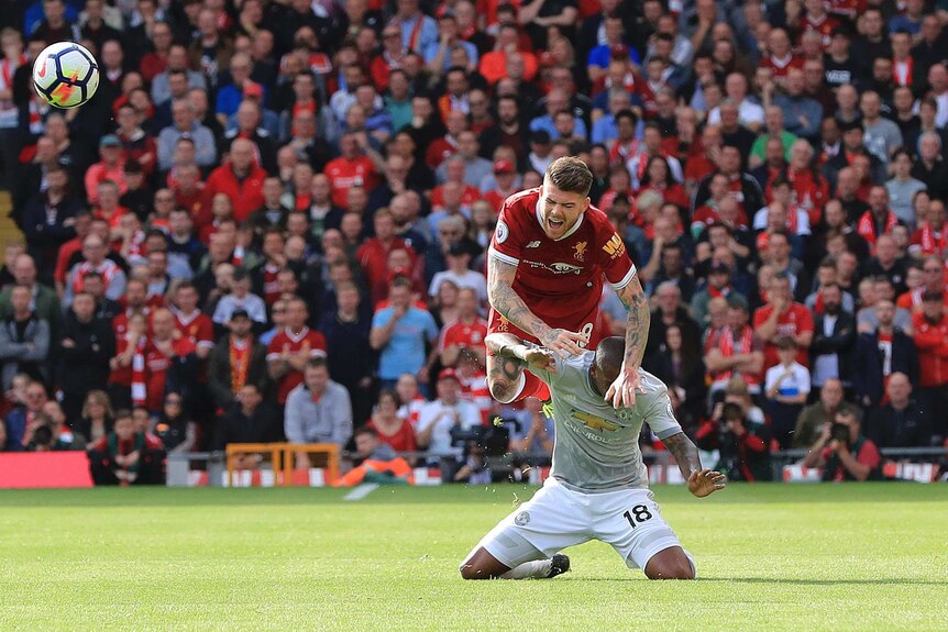 Liverpool's Alberto Moreno goes over the top of Manchester United's Ashley Young at Anfield.