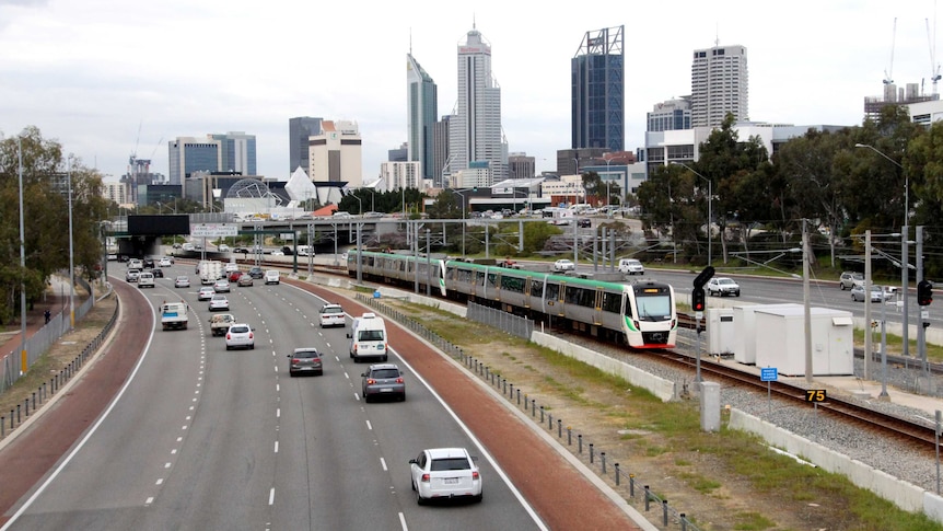 Mitchell Freeway in Perth with Transperth train approaching station