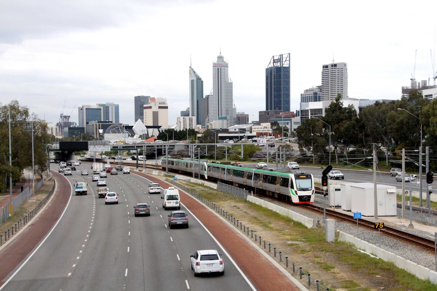 Mitchell Freeway in Perth with Transperth train approaching station