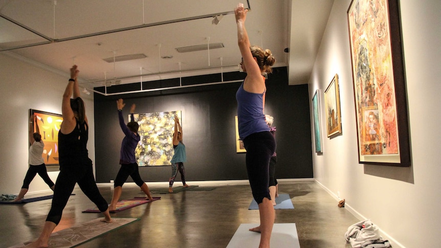 Yoga students in an art gallery